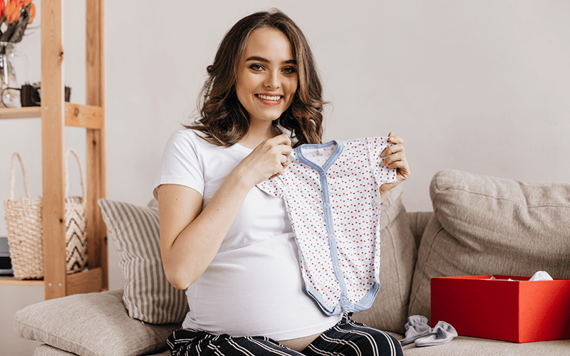 Colaboradora segurando seu Kit Maternidade